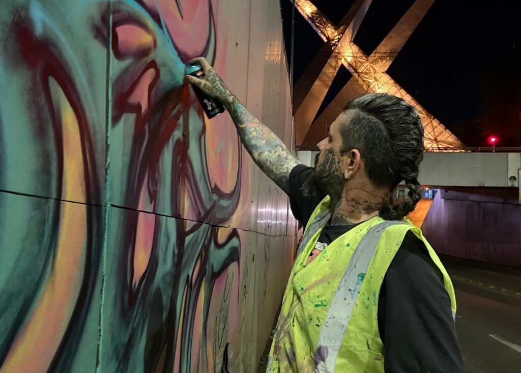Adrien Dorme fazendo mural na Avenida 85, em Goiânia (Foto: divulgação)